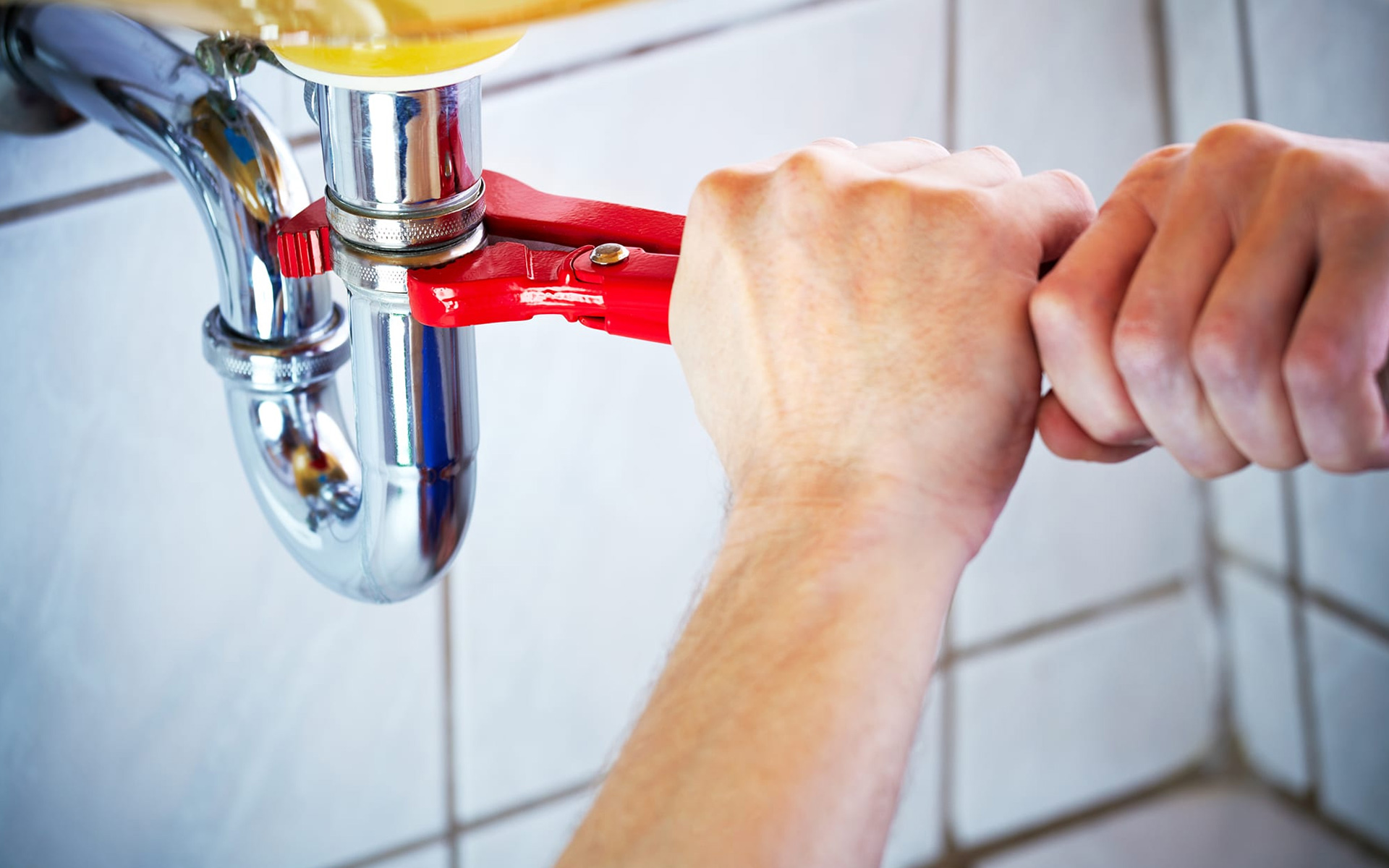 Instalatérská práce — utahování sifonu pod umyvadlem